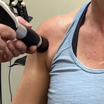 Dr Cohen is applying Shockwave Therapy to the front of the shoulder